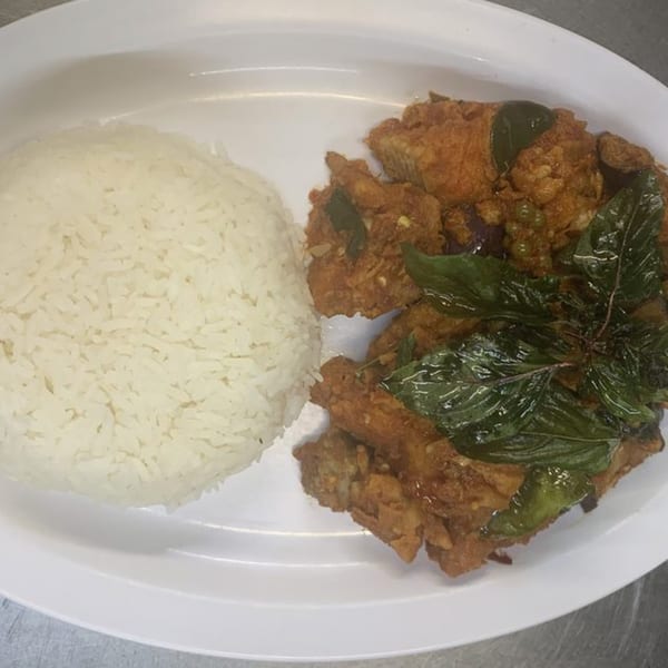 Thai basil chicken with white rice on a white oval plate.