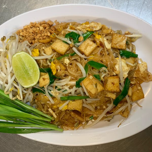 A plate of Sapp Coffee Shop's Pad Thai with noodles, tofu, bean sprouts, peanuts, and lime.