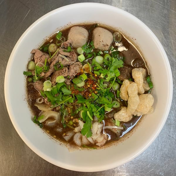 A bowl of Sapp Coffee Shop's Thai boat noodles with beef, meatballs, and pork rinds.