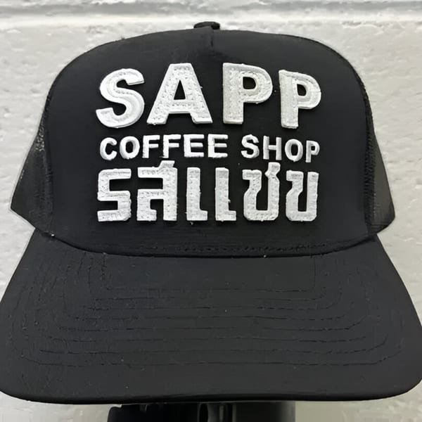 Black Sapp Coffee Shop trucker hat with white embroidered logo in English and Thai script.